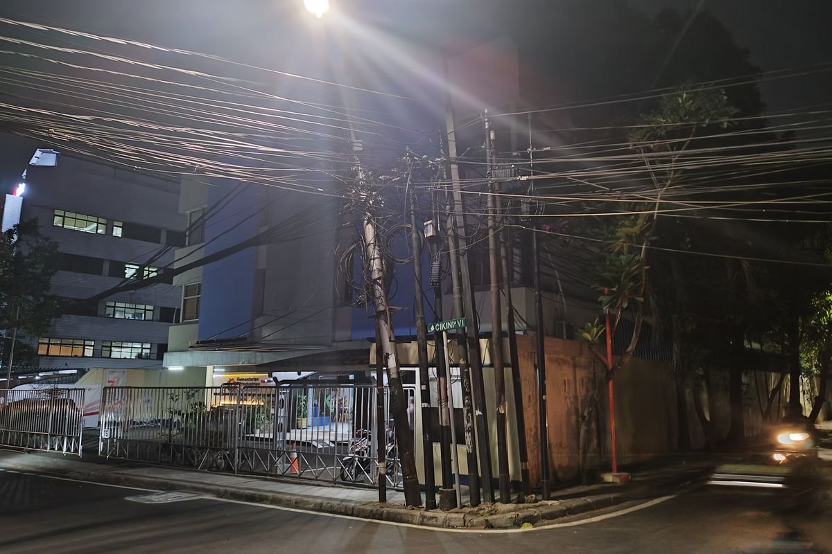 Tiang listrik miring akibat terbebani gulungan kabel fiber optik di Jalan Cikini IV, Menteng, Jakarta Pusat, Kamis (7/9/2023). (KOMPAS.com/XENA OLIVIA)