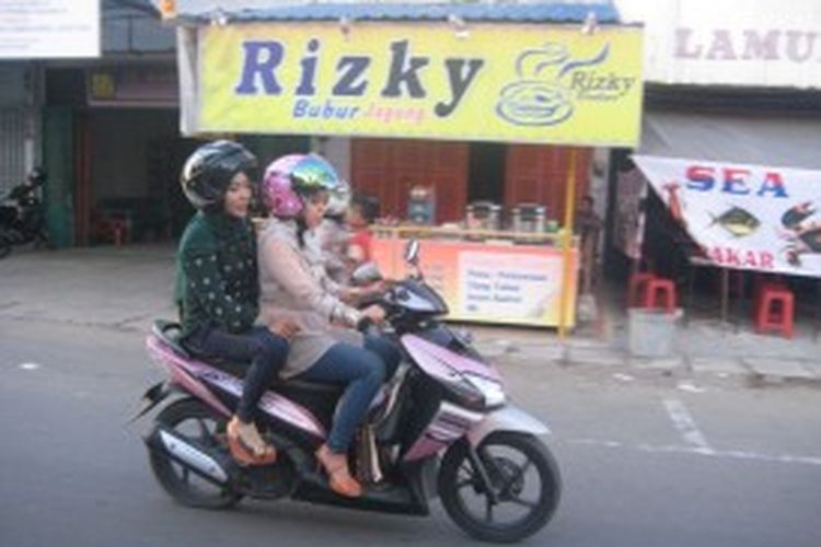 Dua perempuan yang mengenakan celana jins ketat dan duduk mengangkang mengendarai sepeda motor di Kota Lhokseumawe, Provinsi Aceh, Minggu (23/6/2013), meskipun ada larangan mengenakan celana jins ketat dan duduk mengangkang bagi kaum perempuan yang dibonceng sepeda motor.