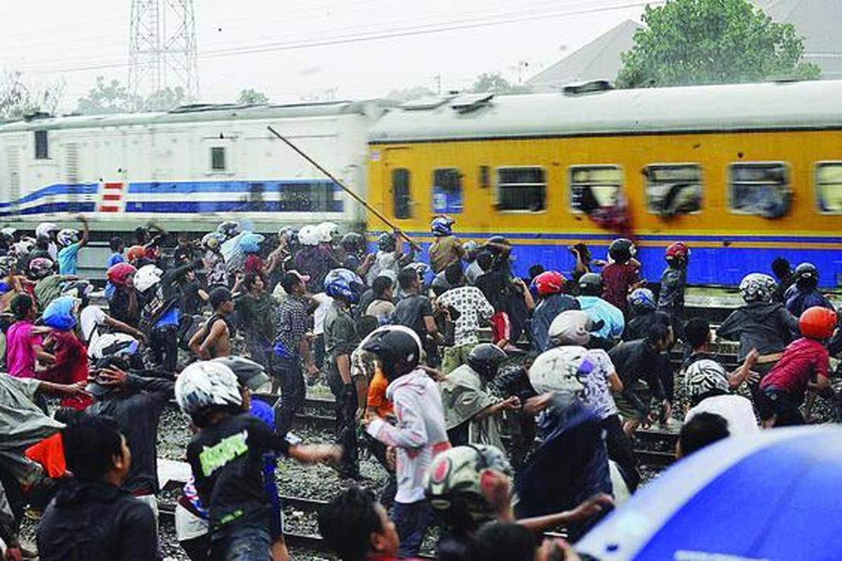 Massa melempari Kereta Api Pasundan yang membawa suporter Persebaya Surabaya, yang biasa disebut bondo nekat (bonek), dari Bandung tujuan Surabaya, di Stasiun Purwosari, Solo, Jawa Tengah, Minggu (24/1). Aksi itu diklaim sebagai balasan terhadap ulah bonek yang melakukan pelemparan batu dan penjarahan makanan di sejumlah stasiun di Solo saat mereka akan berangkat ke Bandung, Jumat lalu. Akibat peristiwa itu, hampir semua kaca kereta pecah.