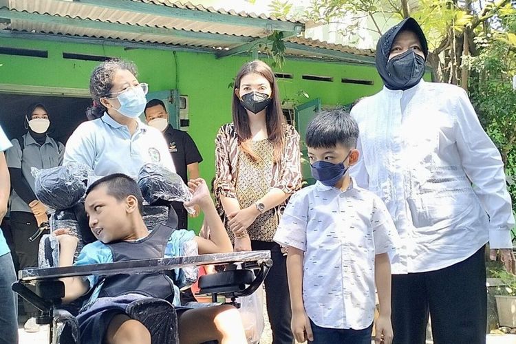 Menteri Sosial Tri Rismaharini didampingi Wali Kota Solo Gibran Rakabuming Raka beserta istrinya Selvi Ananda dan putra sulungnya Jan Ethes Srinarendra memberikan bantuan kursi roda adaptif kepada bocah penyandang cerebral palsy, Yohanes Grabriel Bayu Pratama di Pucangsawit, Kecamatan Jebres, Solo, Jawa Tengah, Senin (25/7/2022).