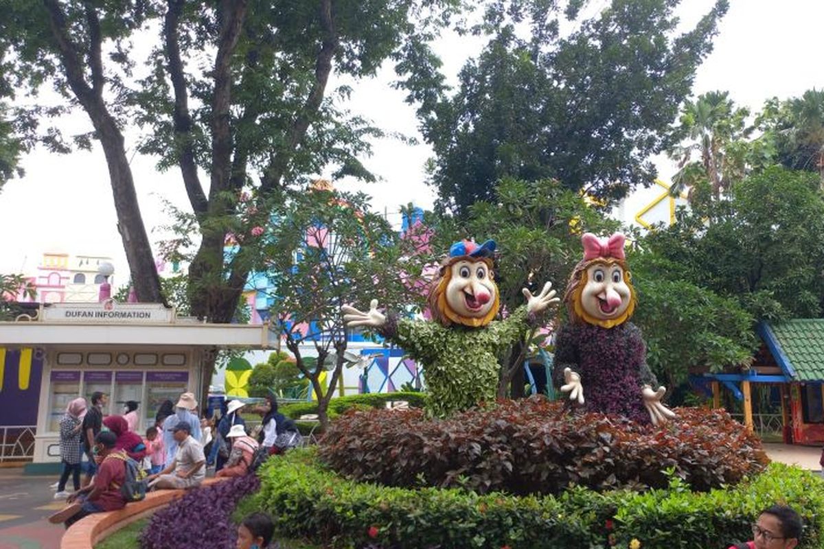 Sejumlah pengunjung tampak beristirahat di dekat dua buah patung maskot Dufan dari jenis kera Bekantan di kawasan unit rekreasi Dunia Fantasi, Taman Impian Jaya Ancol, Pademangan, Jakarta Utara, Kamis (22/12/2022). 