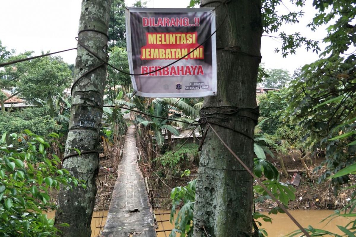 Jembatan gantung Indiana Jones di RT 011 RW 002 Kelurahan Srengseng Sawah, Jagakarsa, Jakarta Selatan, dipasangi spanduk larangan untuk dilintasi. Jembatan ini tidak akan dibangun dengan jembatan baru yang permanen. Foto diambil Selasa (13/3/2018).