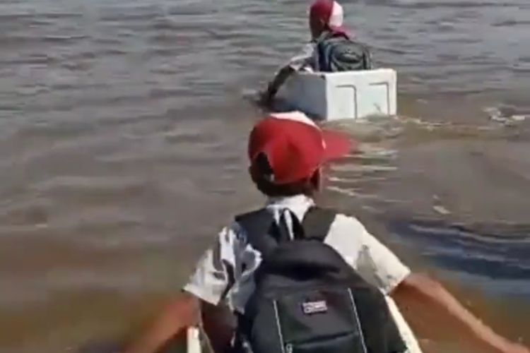 Anak SD di Desa Kuala 12, Kecamatan Tulung Selapan, menggunakan kotak styrofoam bekas untuk menyeberang sungai.