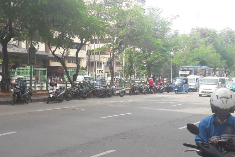 Sejumlah sepeda motor milik pengemudi ojek online diparkir di tepian jaur Transjakarta di Mangga Dua, Jakarta Utara, Minggu (15/4/2018).