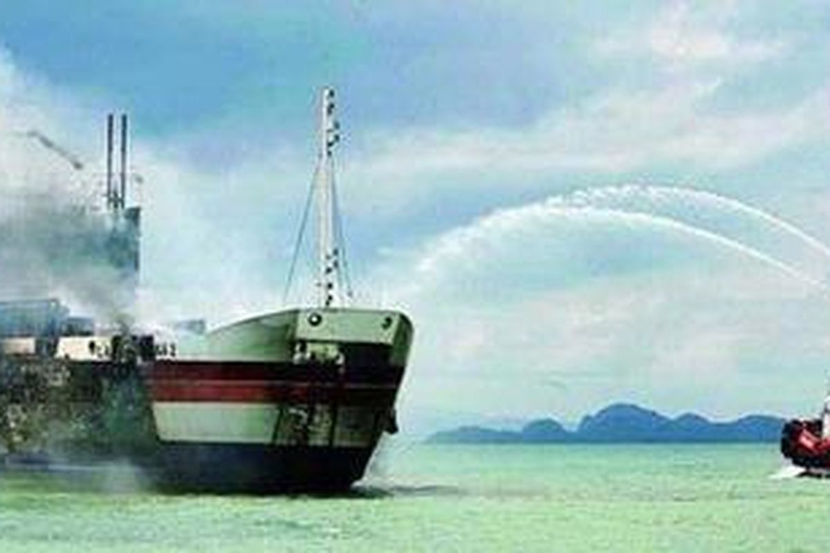 Kapal Gunung Santri (kanan) menyemprotkan air untuk memadamkan api yang membakar Kapal Motor Penumpang Laut Teduh 2 yang terbakar saat melakukan perjalanan dari Merak menuju Bakauheni di kawasan Pantai Anyer, Provinsi Banten, Jumat (28/1/2011). Sedikitnya 13 penumpang tewas dalam peristiwa itu.