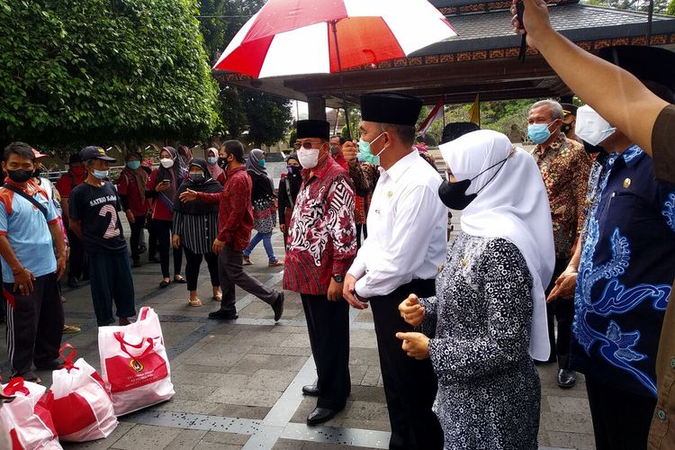 Menko PMK Muhadjir Effendy membagikan bantuan beras kepada sejumlah pedagang asongan di sekitar kompleks Makam Bung Karno, Kota Blitar, Minggu (29/8/2021)