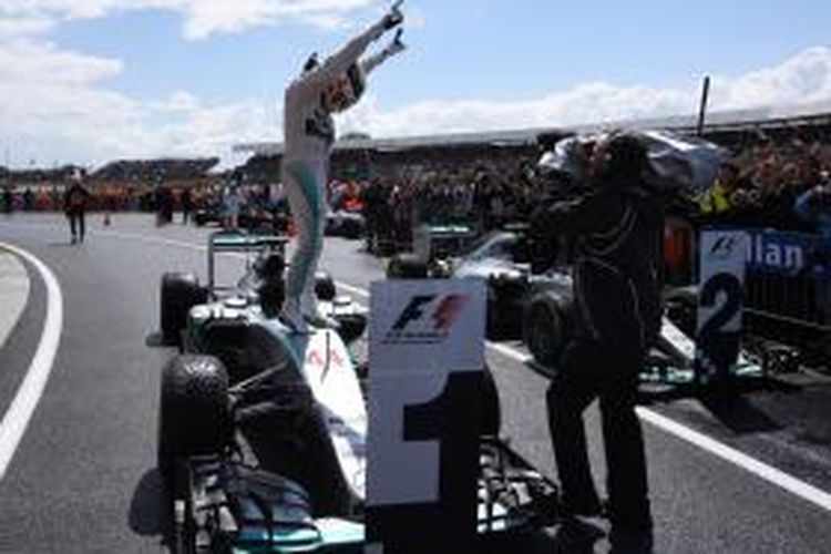 Pebalap Mercedes asal Inggris, Lewis Hamilton, merayakan kemenangan pada GP Inggris di Sirkuit Silverstone, Minggu (5/7/2015).