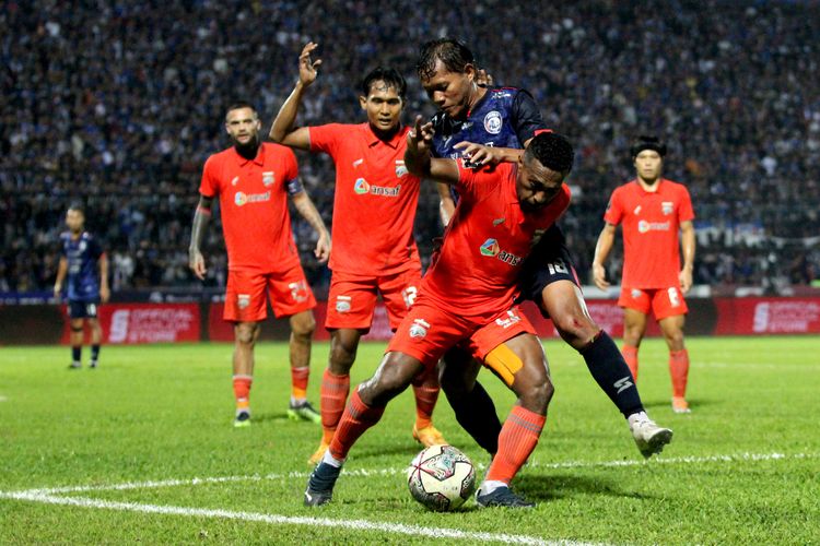 Pemain Arema FC Adam Alis berebut bola dengan pemain Borneo FC Terens Puhiri saat pertandingan leg pertama Final Piala Presiden 2022 yang berakhir dengan skor 1-0 di Stadion Kanjuruhan Kepanjen, Kabupaten Malang, Kamis (14/7/2022) malam.