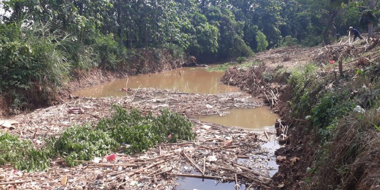 Tampak sampah bambu dan potongan kayu penuhi aliran Kali Cikeas di perbatasan antara Jatiasih, Kota Bekasi dengan Bojongkulur, Kabupaten Bogor, Senin (19/11/2018).