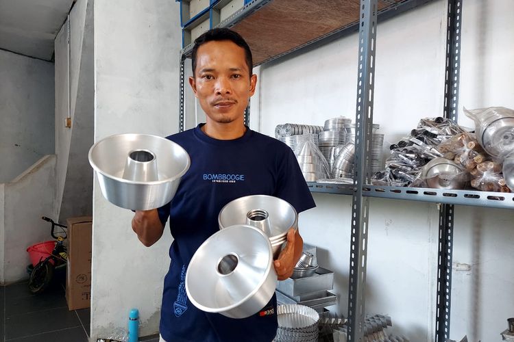Munji (36) perajin perkakas logam dari Citeureup Kabupaten Bogor Jawa Barat memamerkan loyang cetakan kue produksinya