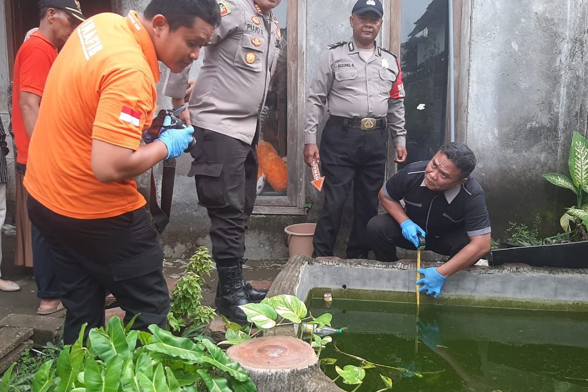 Aparat kepolisian saat melakukan olah TKP balita kembar yang ditemukan tewas terapung di kolam ikan depan rumahnya di Desa Babadan, Kecamatan Pace, Kabupaten Nganjuk, Jawa Timur, Jumat (10/1/2025)
