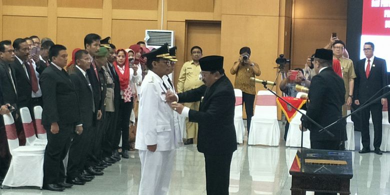 Gubernur Jawa Timur Soekarwo memasangkan lencana kepada Bupati Tulungagung Syahri Mulyo di Kantor Kementerian Dalam Negeri, Jakarta, Selasa (25/9/2018)