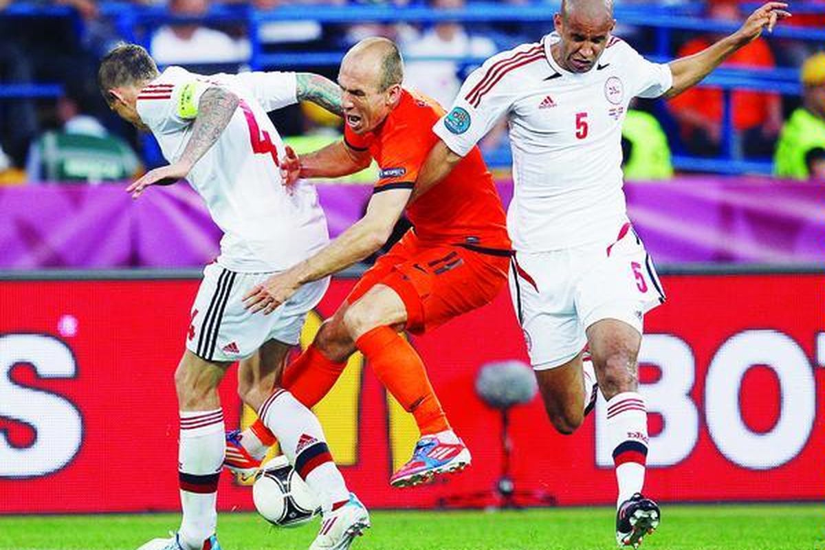 Pemain sayap Belanda, Arjen Robben, ditekel bek tengah  Denmark Daniel Agger  (kiri) dan Simon Busk Poulsen dalam laga Grup B Piala Eropa 2012  di Kharkiv, Ukraina, Sabtu (9/6). Di luar dugaan, Belanda kalah 0-1 di tangan tim Dinamit Denmark.