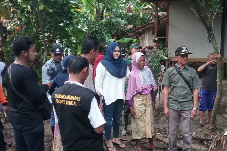 Karyati saat memperlihatkan lokask rumahnya yang hanyut kepada bupati Kendal, Mirna Anissa. Kompas.Com/Slamet Priyatin