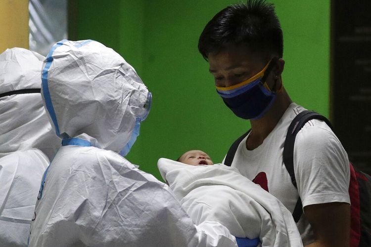 FILE - In this April 28, 2020, file photo, Ronnel Manjares, right, receives his 16-day-old baby Kobe who recovered from COVID-19 as they discharge him from the National Childrens Hospital in Quezon city, Metro Manila, Philippines. Kobe was heralded as the countrys youngest COVID-19 survivor. But the relief and joy didnt last. Kobe died on June 4 from complications of Hirschsprung disease, a rare birth defect. (AP Photo/Aaron Favila, File)