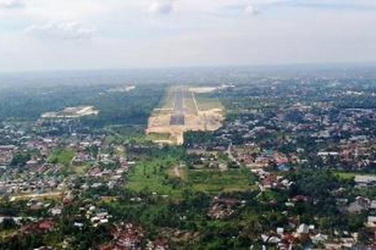 Kota Pekanbaru dengan latar landas pacu Bandara Sultan Syarif Kasim II yang tengah diperpanjang untuk meningkatkan kapasitas penumpang.