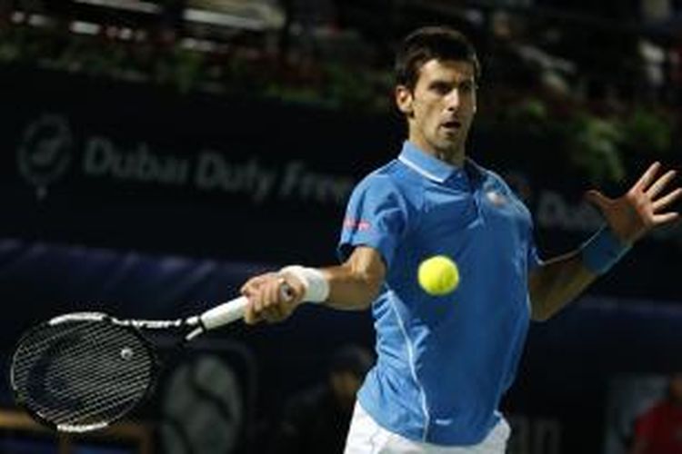 Petenis Serbia, Novak Djokovic, mengembalikan bola ke arah petenis Ceko, Tomas Berdych, pada laga semifinal Dubai Duty Free Tennis Championships, Jumat (27/2/2015). Djokovic menang 6-0, 5-7, 6-4.