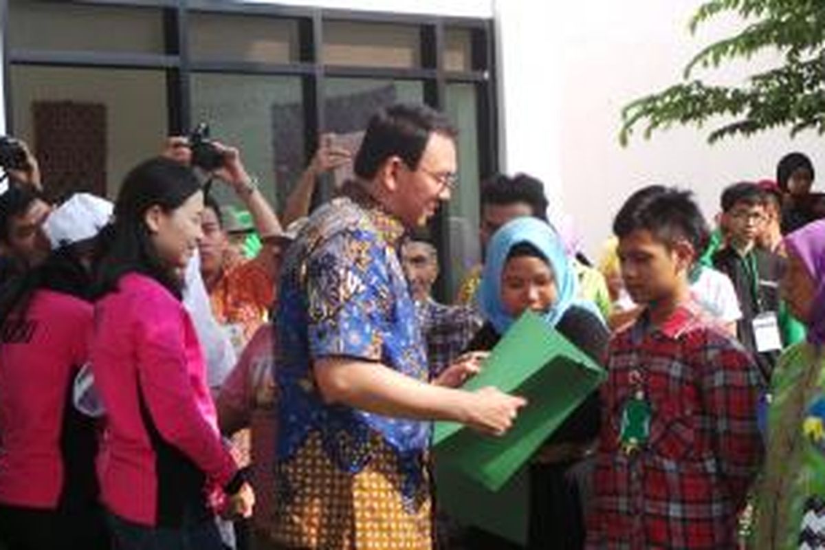 Gubernur DKI Jakarta Basuki Tjahaja Purnama saat menyerahkan bantuan kepada warga dalam peresmian Ruang Publik Terpadu Ramah Anak (RPTRA) Bahari, Gandaria Selatan, Jakarta Selatan, Kamis (21/5/2015). 