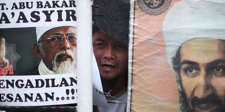 Seorang pendukung Abu Bakar Baasyir memegang spanduk bergambarkan Baasyir dan pemimpin Al Qaeda kala itu, Isama bin Laden, Pengadilan Negeri Jakarta Selatan pada 16 Juni 2011.