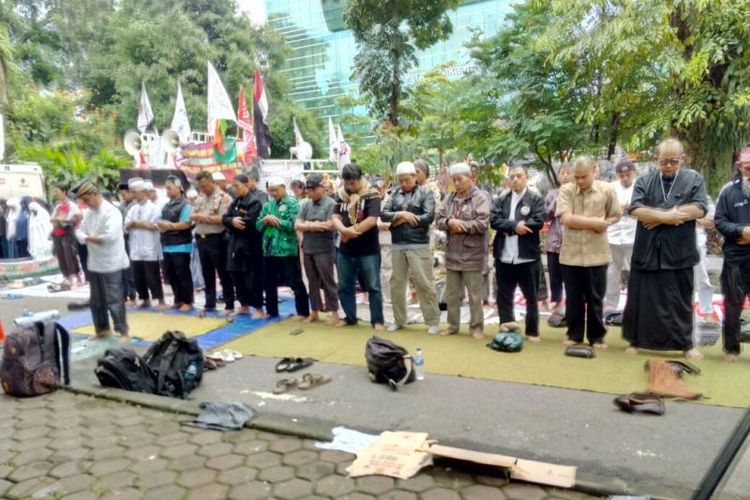 Sejumlah massa pembela Buni Yani menghentikan sementara orasinya untuk melakukan shalat Dzuhur berjamaah didepan Gedung Dinas Perpustakaan dan Kearsipan, Kota Bandung, di jalan Seram, Selasa (14/11/2017).