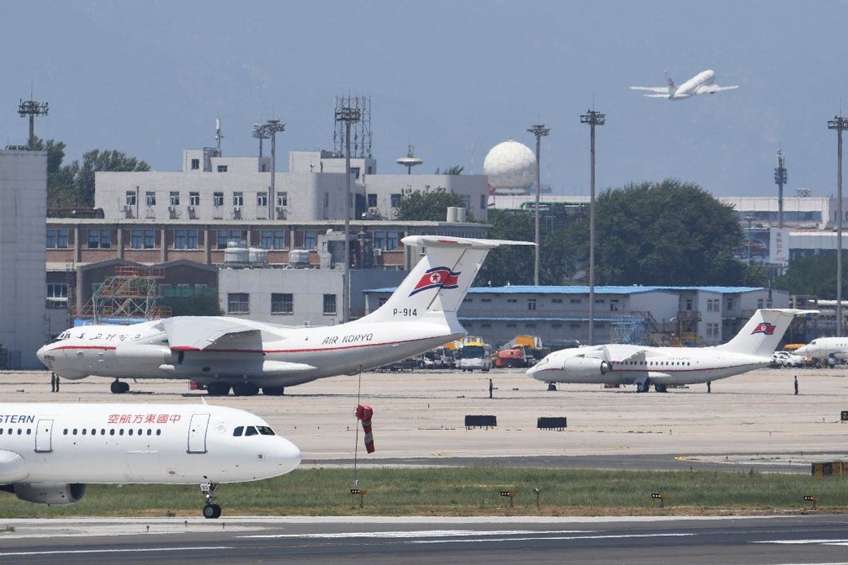 Sebuah pesawat angkut Il-76 dan (kiri) dan pesawat regional An-148 (kanan) milik maskapai penerbangan Korea Utara, Air Koryo, terlihat diparkir di dekat terminal VIP di bandara Beijing, sementara sebuah pesawat China Eastern Airlines (kiri depan) meluncur menuju landasan pacu pada tanggal 20 Juni 2018. 