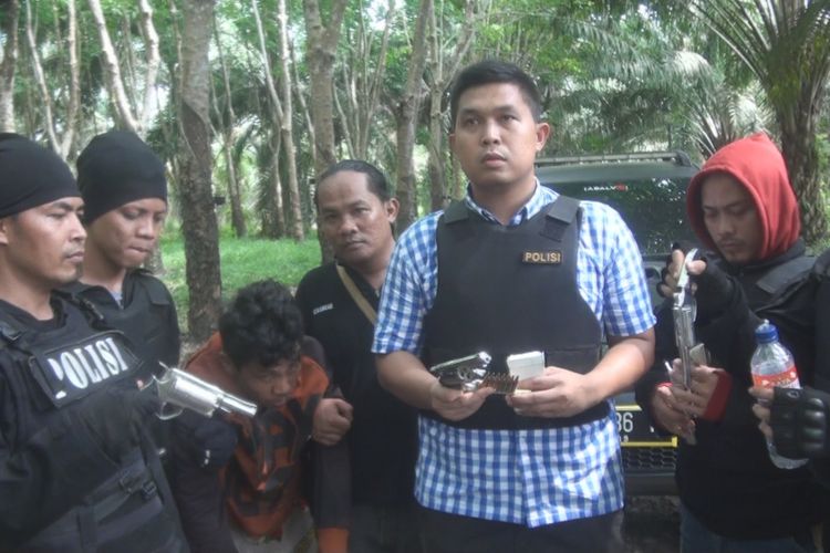 Kasat Reskrim Polres OKI AKP Haris Munandar memperlihatkan empat buah senpi rakitan ilegal beserta 17 butir amunisi yang disita dari rumah tersangka Deri di Desa Sungai Menang OKI.