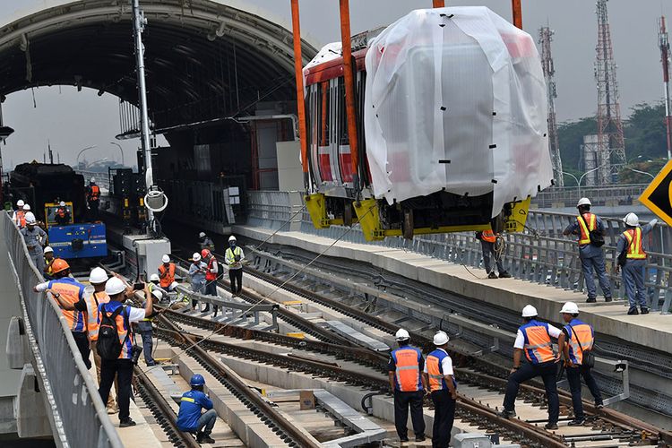 Sejumlah petugas mengawasi proses pengangkatan gerbong kereta light rail train atau lintas rel terpadu (LRT) ke atas rel di Stasiun Harjamukti, Cimanggis, Kota Depok, Jawa Barat, Rabu (4/12/2019). Saat ini sebanyak dua dari total 31 rangkaian kereta (train set) LRT buatan PT INKA telah diangkat di atas rel Stasiun Harjamukti dan ditargetkan selesai seluruhnya pada 2020.