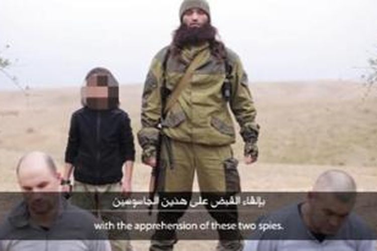 Dalam video terbaru ISIS, menampilkan seorang bocah laki-laki berusia kurang lebih 10 tahun mengeksekusi dua pria yang dituduh sebagai mata-mata Rusia.