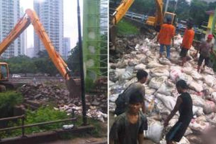 Alat berat dan pekerja dikerahkan untuk menempatkan tumpukan karung pasir di tanggul Kanal Banjir Barat, Senin (13/1/2014). Pemasangan karung pasir dilakukan untuk mengantisipasi kenaikan muka air di kanal tersebut seperti terjadi tahun lalu.