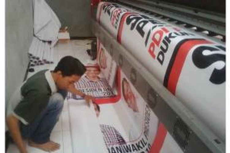 Salah satu karyawan di percetakan di Kota Malang, menyelesaikan pesanan benner ucapan selamat dilantiknya presiden terpilih Jokowi-JK. Jumat (17/10/2014).