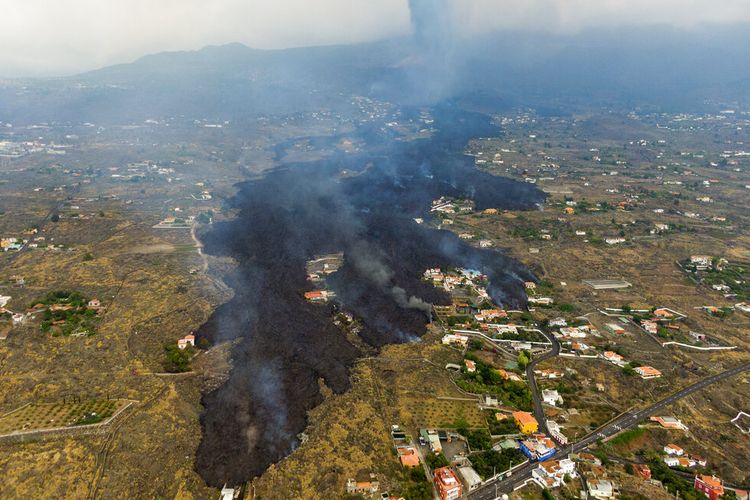 FILE - Dalam file foto Selasa, 21 September 2021 ini, lava dari letusan gunung berapi mengalir menghancurkan rumah-rumah di pulau La Palma di Canaries, Spanyol. 