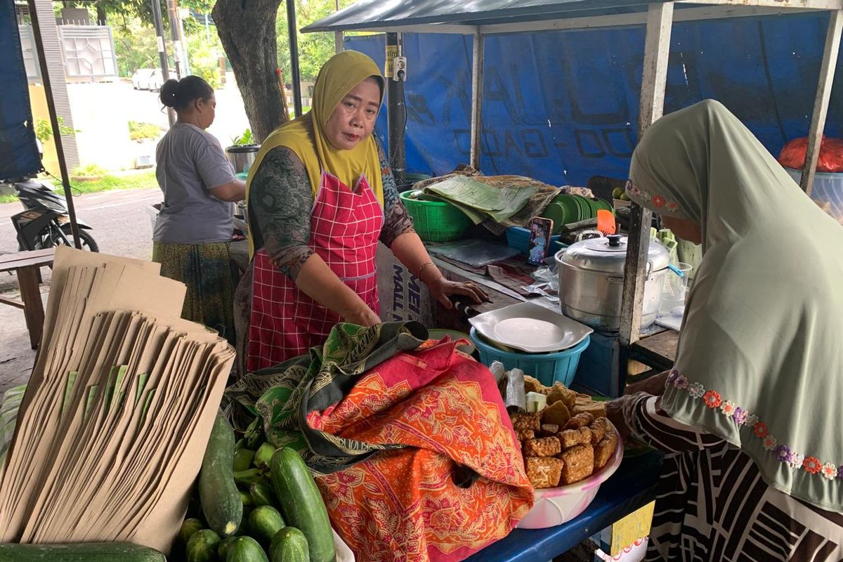 ULEK SAUS—Mbak Pur, pemilik warung Rujak Petis Pojok sementara mengulek saus yang terbuat aneka rempah sebelum dituangkan di Rujak Petis Madiun