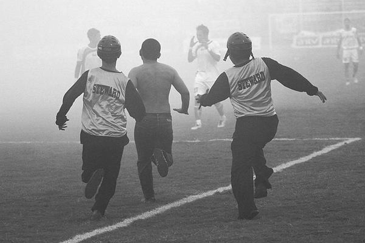 Sejumlah petugas mengejar suporter yang memasuki lapangan  dalam pertandingan Pelita Jaya melawan Persija Jakarta dalam Liga Super Indonesia  di Stadion Manahan, Solo, Jawa Tengah, Senin (23/1). Persija mengalahkan Pelita dengan skor 2-0.