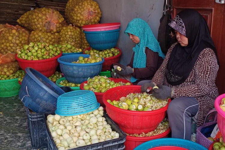 Ibu-ibu di Dusun Kekep, Desa Tulungrejo, Kota Batu yang bekerja di tempat produksi keripik buah milik Lilik Sumarlik sedang mengupas apel pada Minggu (9/4/2023). 