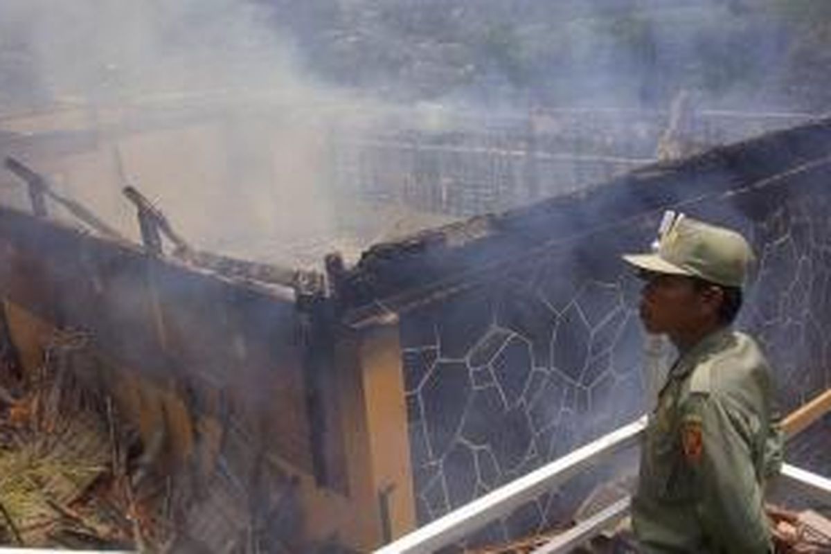 Vila Orange milik Panjaitan terbakar saat terjadi bentrokan antar massa yang menolak pembongkaran di Desa Sirnagalih, Kabupaten Bogor, Kamis (12/12/2013).