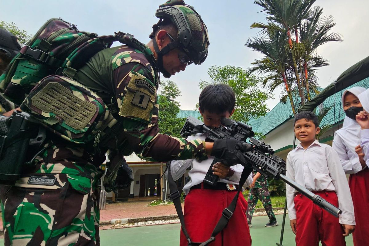 Seorang pelajar SD di Kota Bogor, Jawa Barat, sedang memegang senjata dalam pameran alat utama sistem pertahanan (alutsista) yang diadakan Korem 061/Suryakencana dalam rangka HUT yang ke-74.