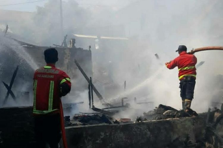 Petugas Damkar Sumedang berjibaku padamkan api yang melalap tiga rumah di Lingkungan Gunung Cina, Sumedang, Jawa Barat, Minggu (18/4/2021) siang. AAM AMINULLAH/KOMPAS.com