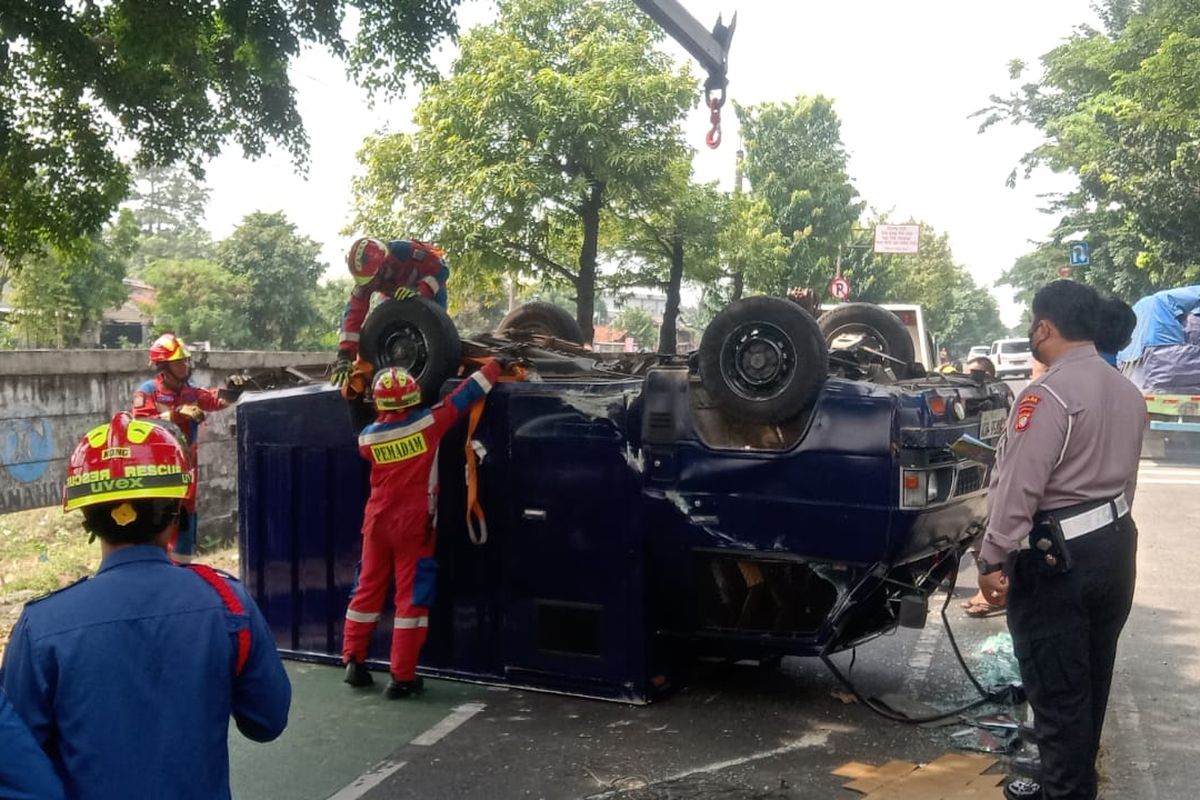 Proses evakuasi mobil pengangkut uang yang terbalik di Jalan I Gusti Ngurah Rai, Senin Siang.