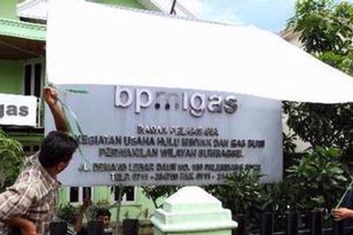 Pekerja sedang menutup papan nama di kantor BP Migas Sumsel, Jalan Demang Lebar Daun, Palembang, Rabu (14/11/2012). Penutupan ini merupakan kebijakan dari kantor pusat pascaputusan Mahkamah Konstitusi (MK) yang membatalkan sejumlah poin di UU Migas yang berujung pada penutupan BP Migas.