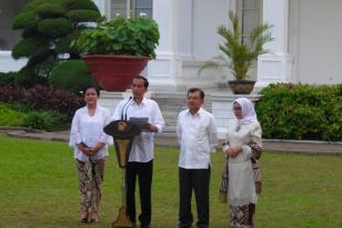 Presiden Joko Widodo dan Wakil Presiden Jusuf Kalla berserta istri masing-masing dalam pengumuman kabinet di halaman Istana Negara, Minggu (26/10/2014).