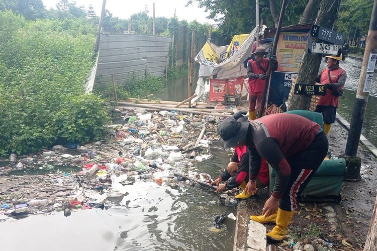 Terlihat anggota Dinas Pekerjaan Umum (DPU) Kota Semarang sedang membersihkan saluran drainase di Jalan Soekarno Hatta, Sambirejo, Gayamsari, Kota Semarang, Jawa Tengah, Selasa (28/10/2025).