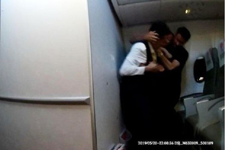 Seorang kru kabin Fuzhou Airlines bergulat dengan seorang penumpang yang berusaha membuka pintu darurat di tengah penerbangan.