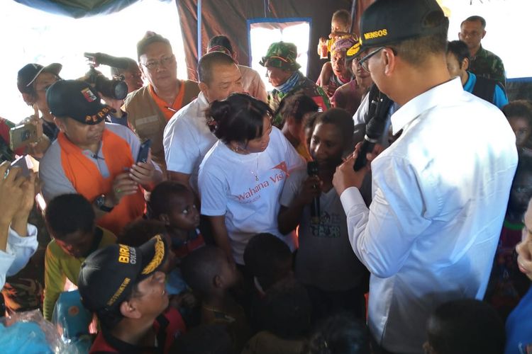 Menteri Sosial Agus Gumiwang Kartasasmita (mengenakan topi) sedang mendengar harapan dari Rini Enundi, salah satu anak-anak yang terdampak banjir bandang yang sedang mengungsi di Stadion Barnabas Youwe, Kabupaten Jayapura, Papua, Rabu (27/3/2019).