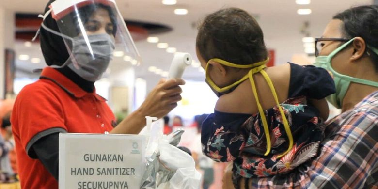 Seorang ibu membawa balitanya belanja di pusat perbelanjaan di Kota Mataram, tanpa perduli resiko tertular corona