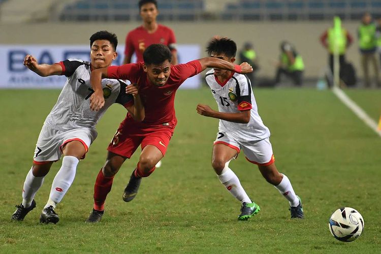 Pesepak bola tim nasional Indonesia U-23 Saddil Ramdani (tengah) berupaya meloloskan diri dari kawalan dua pesepak bola tim nasional Brunei Darussalam U-23 Muhammad Nur (kiri) dan Rahmin Abdul Ghani (kanan), pada pertandingan Grup K kualifikasi Piala Asia U-23 AFC 2020 di Stadion Nasional My Dinh, Hanoi, Vietnam, Selasa (26/3/2019). Tim nasional Indonesia U-23 mengalahkan tim nasional Brunei Darussalam U-23 dengan skor 2-1.