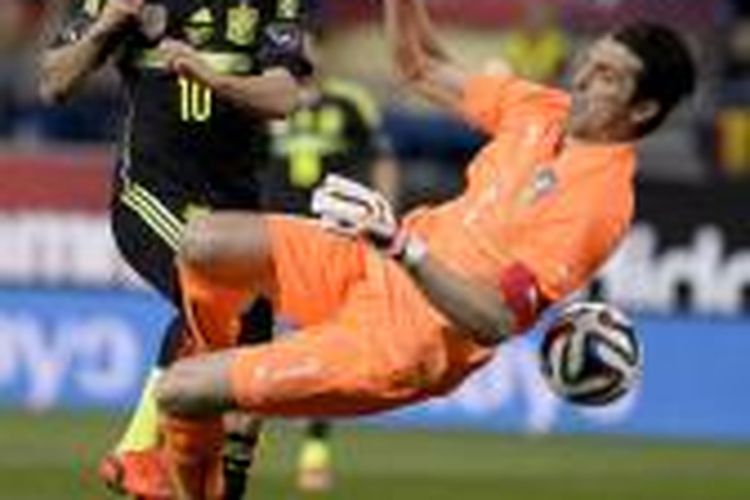 Gelandang Spanyol Cesc Fabregas (kiri) berebut bola dengan kiper Italia Gianluigi Buffon pada pertandingan persahabatan, di Vicente Calderon, 5 Maret 2014.