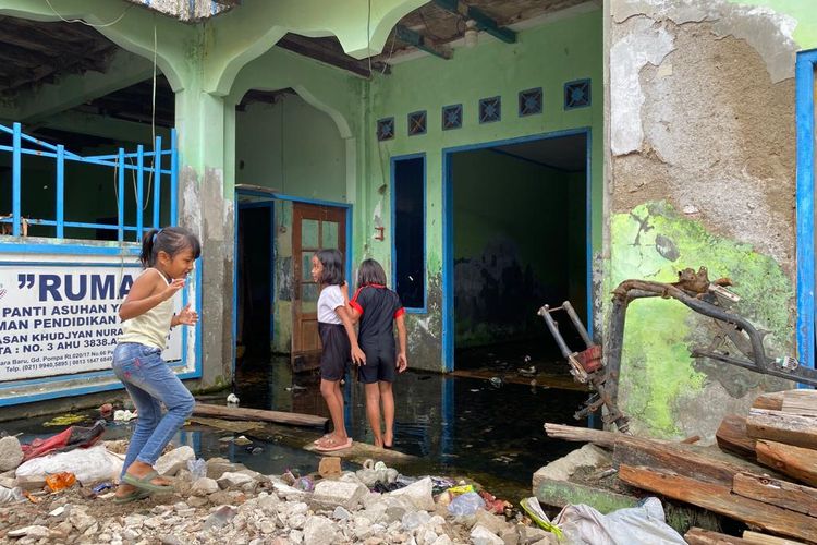 Di kampung apung yang berlokasi di Muara Baru, Penjaringan, Jakarta Utara anak-anak bermain di untuk menghabiskan waktu pada Jumat (27/1/2023) sore. Mereka bermain di area bekas panti asuhan yang terendam air.  