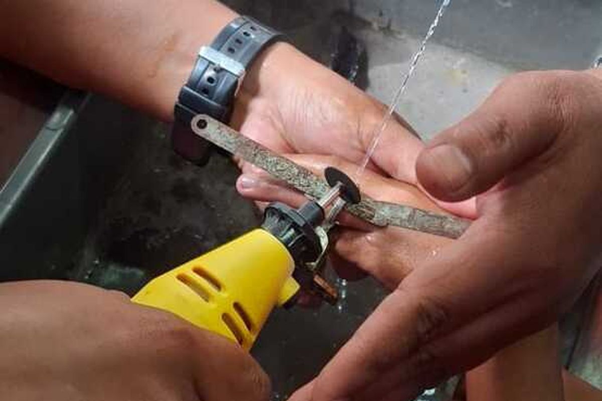 Petugas Diskar PB tengah berupaya mengeluarkan jari seorang anak yang tersangkut di lubang slot kunci jendela, selasa (7/1/2025)