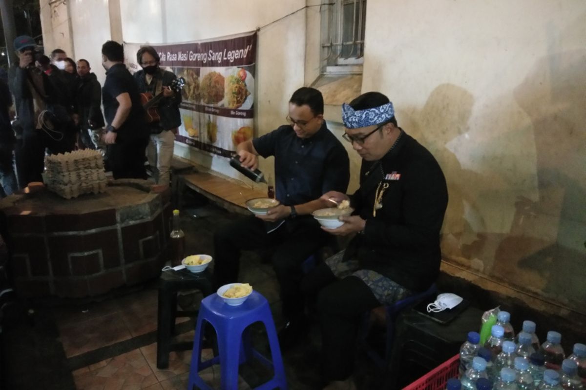 Gubernur Jawa Barat Ridwan Kamil bersama Gubernur DKI Jakarta Anies Baswedan saat menyantap bubur di Jalan Asia Afrika, Kota Bandung, Kamis (24/2/2022) malam.