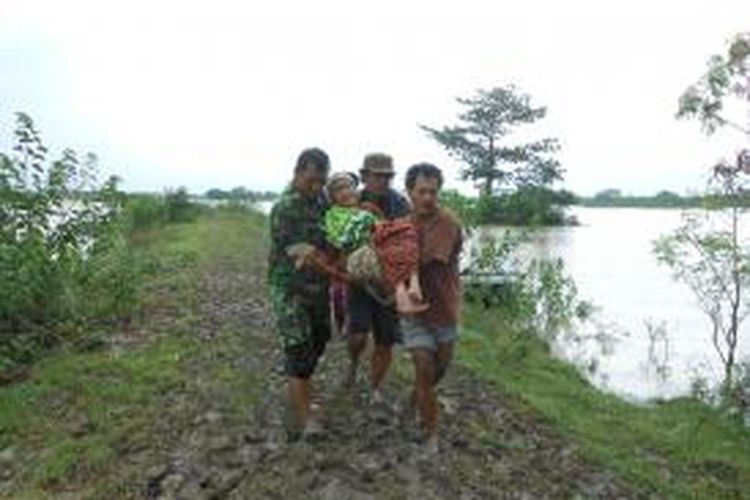 Seorang nenek warga Desa Tedunan Kecamatan Wedung, Demak yang rumahnya terendam banjir, digendong anggota TNI dan warga , karena tidak mampu berjalan ke lokasi pengungsian, Rabu (22/1/2014) 